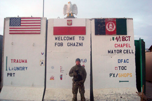 1st Lt Grochmal from the 359th Inland Cargo Transfer Company area poses in front of T-walls on Forward Operating Base Ghazni in Afghanistan circa 2012.