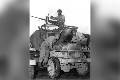 African-American Soldiers work on a truck engine while another works on .50 caliber machinegun as part of the famed Red Ball Express.  Part of the research collection of the U.S. Army Transportation Museum.