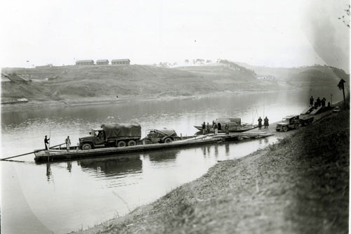A U.S. Army Truck pulling Type A-1 600 gallon Fuel Servicing Trailer on ferry with jeep and trailer waiting to board Ferry at Nihyang China during World War II. 