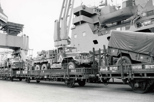 U.S. Army vehicles sitting on rail cars after being unloaded from cargo ship at Nordenham Port after being returned as part of Operation Desert Farwell.  Part of the research collection of the U.S. Army Transportation Museum.