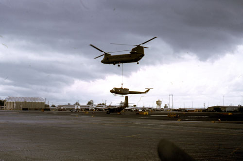 A CH47 from the 330th Transportation Company, 765th Transportation Battalion sling loads a damaged UH-1 in Vietnam, 1970.  Part of the research collection of the U.S. Army Transportation Museum.