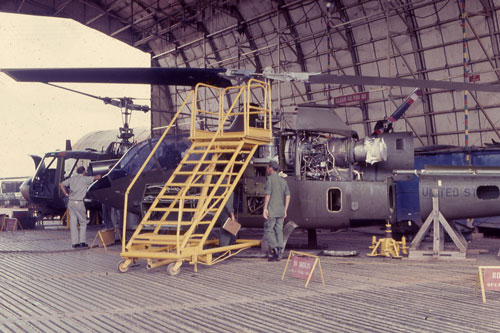 34th General Support Group (Aircraft Maintenance and Supply) repair hanger with a AH-1 and UH-1 both undergoing repair in Vietnam 1967-1968. Part of the research collection of the U.S. Army Transportation Museum.