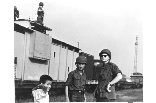American and Vietnamese officers stand in front of an armored rail car in Vietnam 1965.  Part of the research collection of the U.S. Army Transportation Museum.