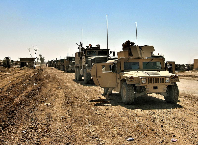 Long caravan of trucks lined up on a road in Iraq