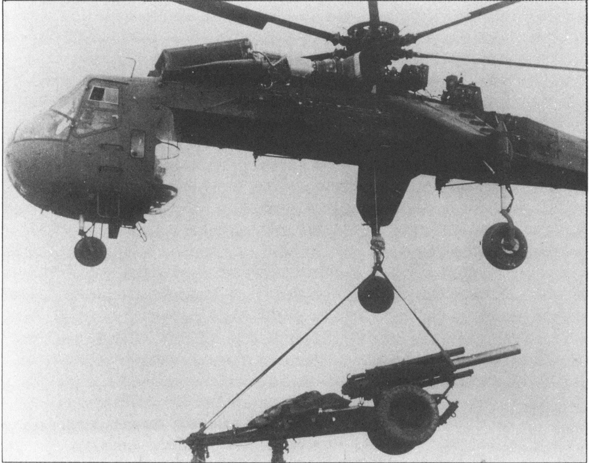 CH-54 Sky Crane (Tarhe) lifting a 105-mm. howitzer at a fire base in Vietnam.