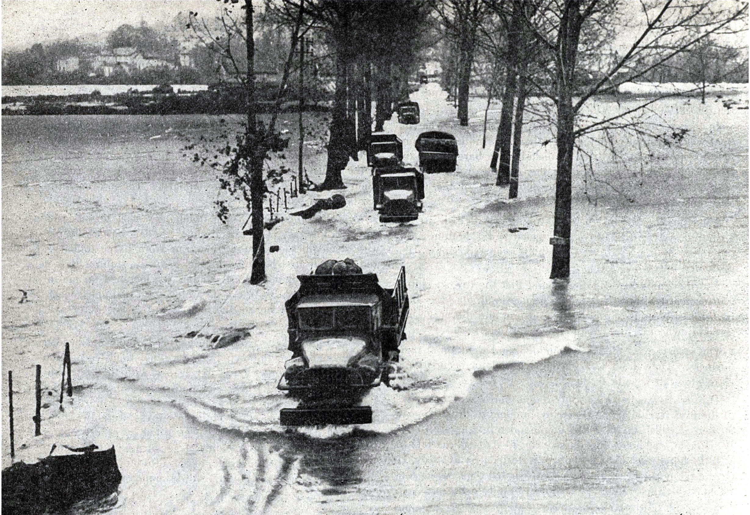 U.S. Army trucks driving through watery roadway. (Photo courtesy of the U.S. Army)