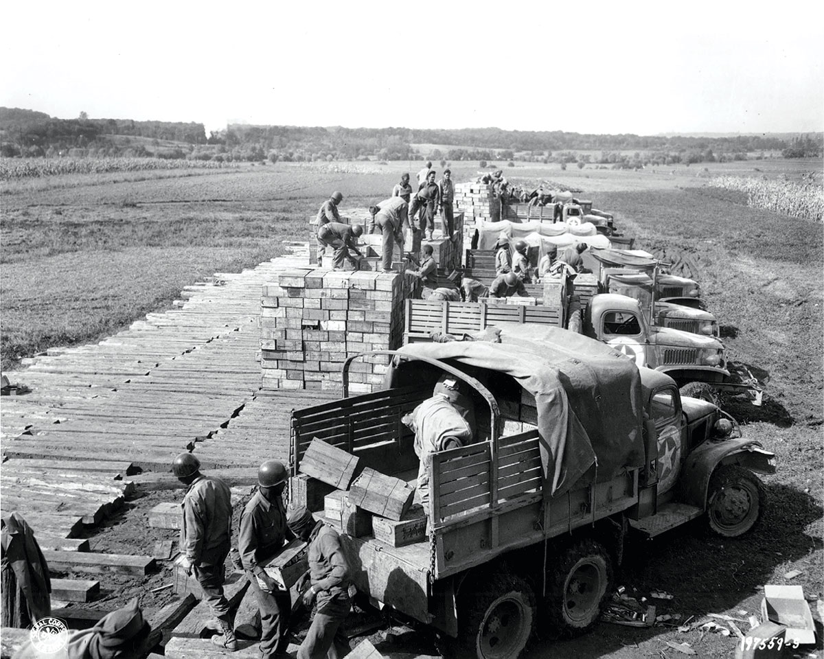 Soldiers load trucks with combat rations in preparation for a convoy to the front line 21 December 1944 in the European theater of operations. (Photo courtesy of the U.S. Army)