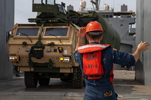 US Army Watercraft Operator directing unloading.