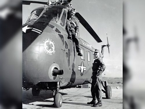 Two soldiers next to H-19 Chickasaw helicopter.