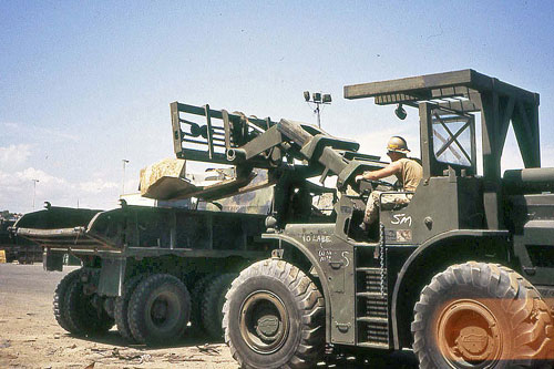 Rough Terrain Forklift in the process of loading a Dump Truck.