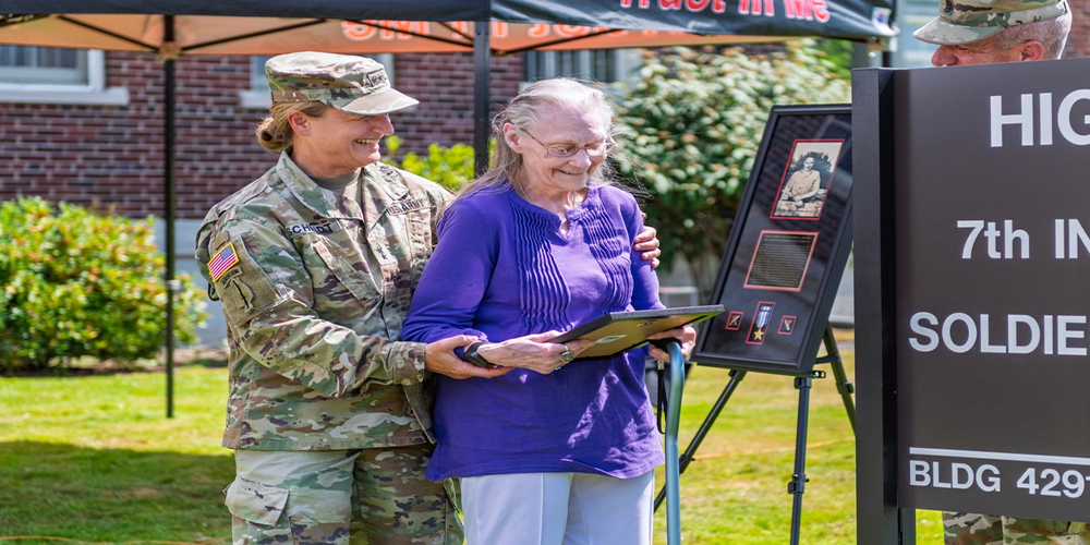 Photo By Allison Hoy | Major General Michelle Schmidt, 7th Infantry Division commanding general, stands with Sandra “Sandy” Naquin and 7th ID Command Sgt. Maj. Stephen LaRocque, viewing a plaque picturing Naquin’s brother, Army Cpl. Frederick Arthur Higgins, a 7th ID Korean War hero. Joint Base Lewis-McChord's newly named Higgins Hall Soldier Service Center was dedicated July 30 to Higgins.
