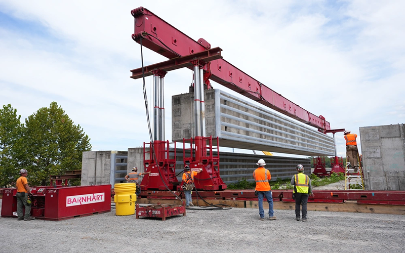 Photo By Noe Gonzalez | SPRING CITY, Tenn. — Barnhart crew members use a hydraulic power system to lift a prefabricated wall beam onto a barge for delivery to the Chickamauga Lock Replacement Project’s upstream approach wall contract near Watts Bar Dam Aug. 28, 2025. (USACE photo by Noe Gonzalez).