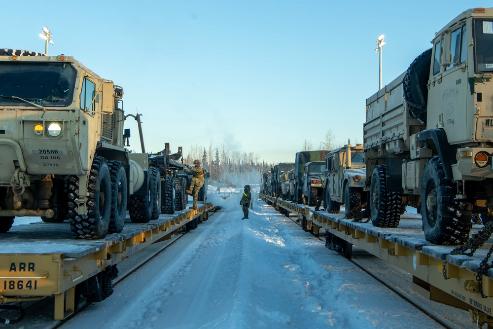 Photo By Senior Airman Patrick Sullivan | U.S. Army Soldiers assigned to the 17th Combat Support Sustainment Battalion and members of the U.S. Air Force's 773rd Logistics Readiness Squadron load vehicles onto rail lines at Joint Base Elmendorf Richardson, Alaska, Jan. 22, 2024, ahead of Joint Pacific Multinational Readiness Center 24-2. In previous iterations of the exercise, most forces and vehicles would convoy the near 400-mile journey from JBER to Fort Wainwright, Alaska. Using rail allows for reduced risk in transiting the often-treacherous Interior. (U.S. Air Force photo by Senior Airman Patrick Sullivan)