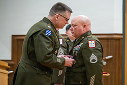 Photo By Melissa Buckley | Staff Sgt. Paul Schmich, Motor Transport Operator Course instructor with the 58th Transportation Battalion, receives a Purple Heart medal from Col. William Arnold, U.S. Army Chief of Transportation during a ceremony Jan. 15 in Fort Leonard Wood’s Lincoln Hall Auditorium.