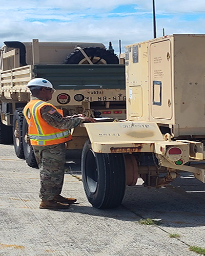Photo By Staff Sgt. Elizabeth Bryson | U.S. Army Sgt. 1st Class Hollingshed, 841st Transportation Battalion, 597th Transportation Brigade, movement supervisor, inspects a deploying unit's trailer and documentation at Hunter Airfield in July 2025.