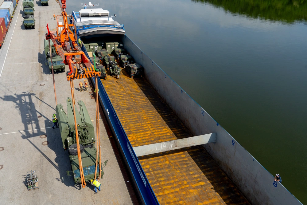 Photo By 1st Sgt. Jacob Connor | A U.S. Army Light Medium Tactical Vehicle (LMTV) assigned to the 7th Engineer Brigade gets prepped before being lifted by a crane to be loaded on a barge during a barge transportation operation supporting Saber Guardian 25 in Passau, Bayern, Germany, on May 21, 2025. River vessels provide the U.S. Army with a tactical advantage by using waterways instead of standard air, rail, or linehaul methods. (U.S. Army photo by 1st Sgt Jacob Connor) Demonstrating global deterrence and the U.S. Army’s ability to rapidly deploy U.S.-based combat power in Europe and the Arctic region alongside Allies and partners, DEFENDER 25 brings U.S. troops together with forces from 29 Allied and partner nations to build readiness through large-scale combat training from May 11-June 24, 2025. DEFENDER 25 increases the lethality of the NATO alliance through large-scale tactical training maneuvers and long-range fires, builds unit readiness in a complex joint, multinational environment and leverages host nation capabilities to increase the U.S. Army’s operational reach. During three large-scale combat training exercises—Swift Response, Immediate Response, and Saber Guardian—Ally and partner forces integrate and expand multi-domain operations capability, demonstrating combined command and control structures and readiness to respond to crisis and conflict.