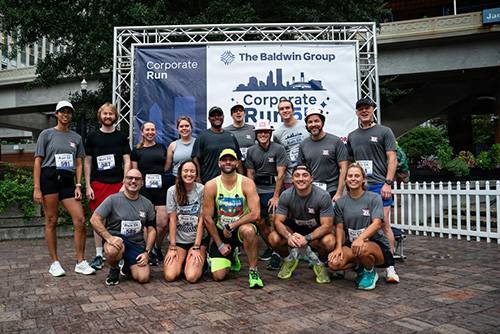 Photo by Brigida Sanchez | The U.S. Army Corps of Engineers Jacksonville District participated in the Baldwin Group Corporate 5k run at the James Weldon Johnson Park in Downtown Jacksonville. 15 of the 21 participants photographed here with pre-run smiles.