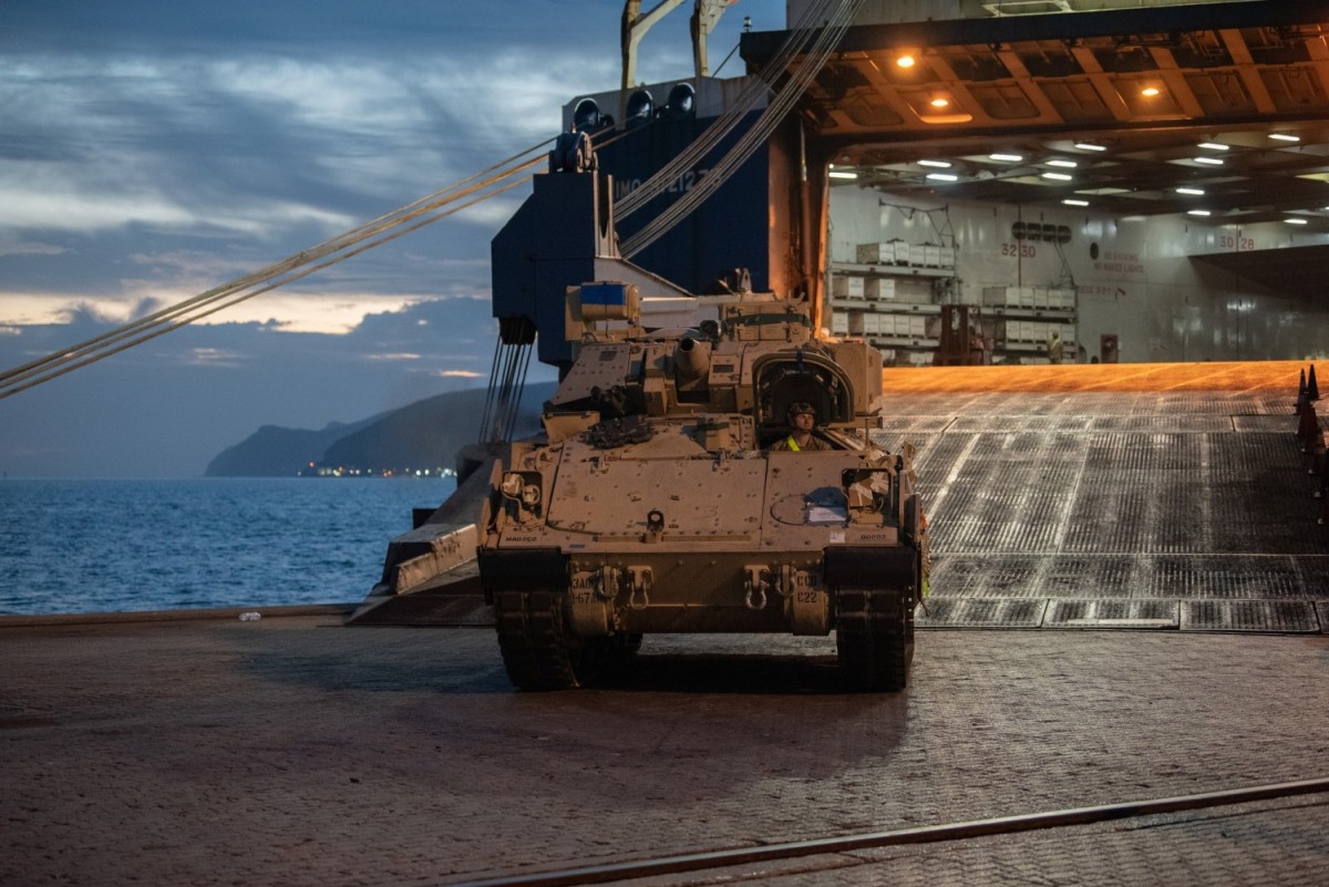 A U.S. Army Soldier belonging to the 3rd Brigade Combat Team, 1st Armored Division, drives a Bradley Fighting Vehicle off the vessel to be logged into a system at a checkpoint at the port of Setúbal, Portugal