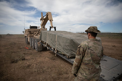 Sgt. William Bachman, a motor transport operator with340th Brigade Support Battalion, California National Guard, unloads a flat of 155mm howitzer rounds during Western Strike 22 at Orchard Combat Training Center, Idaho, June 10, 2022. Western Strike 22 is an eXportable Combat Training Capabilities exercise led by the 65th Field Artillery Brigade, Utah National Guard, that provides National Guard Soldiers immersed training similar to a combat training center and aims to increase participating unit's readiness and lethality.(Photo by Sgt. James Bunn, 128th Mobile Public Affairs Detachment)