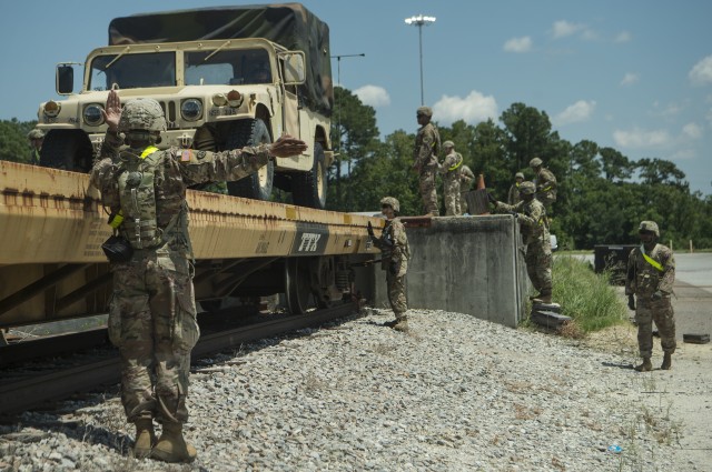 Soldiers from the Transportation Corps loading vehicles onto a train.