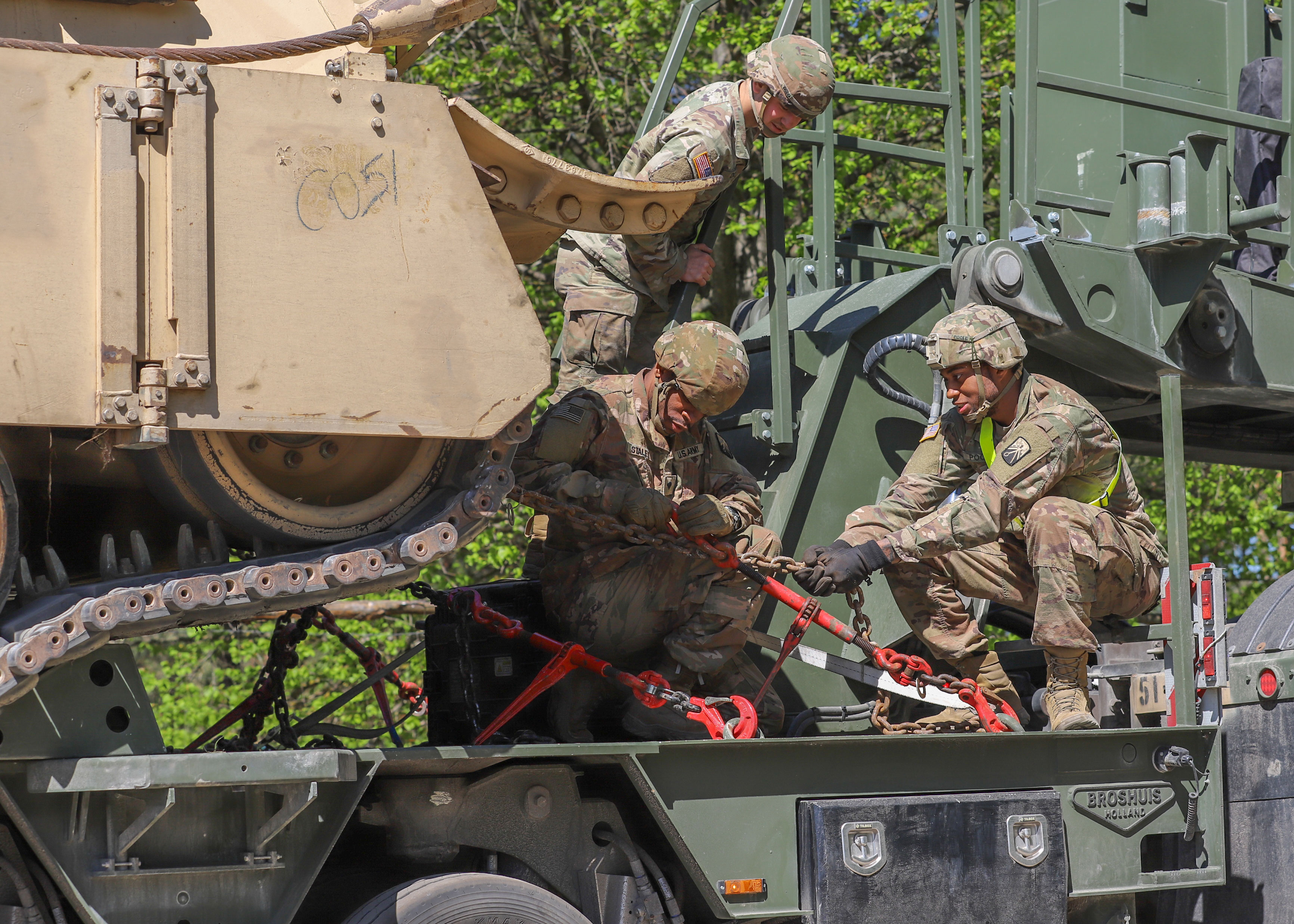 U.S. Soldiers assigned to the 51st Composite Truck Company, 8th Combat Sustainment Support Battalion, 16th Sustainment Brigade, begin preparing large armored vehicles for transportation towards the Narew river during Defender Europe at Lomza, Poland, May 17, 2022. Defender Europe 22 is a series of U.S. Army Europe and Africa multinational training exercises in Eastern Europe. The exercise demonstrates U.S. Army Europe and Africa’s ability to conduct large-scale ground combat operations across multiple theaters supporting NATO. (U.S. Army photo by Spc. Devin Klecan).