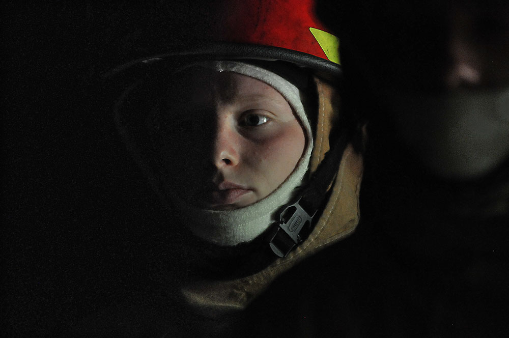 Pvt. Sidney Little, an 88K Watercraft Operator Course student, listens to the brief with other students in the darkness of the fire trainer April 16 at Joint Base Langley-Eustis. Little and her classmates would later don equipment to fight flames in smoke-filled, dark spaces with temperatures over 300-degrees.