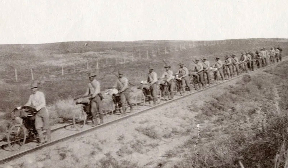 To avoid thick mud and soft sand, the soldiers walked their bikes along railroad tracks. National Archives