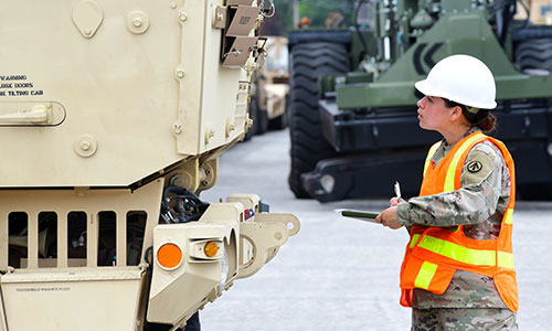 Transportation soldier uses command signals to a fellow transportation soldier in a military vehicle in a movement control operation mission.